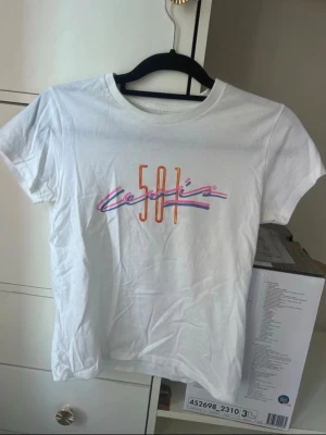 🤍 Levi's vit T-shirt med färgat tryck | XS | Logo Tee - Säljer en snygg vit Levi's T-shirt med färgat tryck i storlek XS. En klassisk och stilren T-shirt som är enkel att matcha med jeans, shorts eller kjol. Perfekt som ett basplagg med en färgglad detalj.