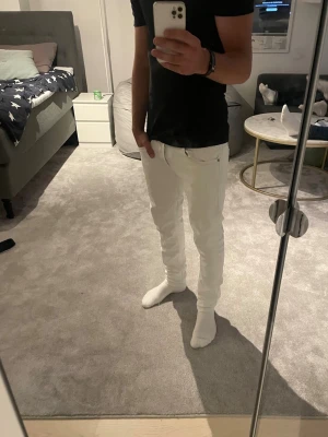 Vita dondup George  - Säljer ett par vita slim fit jeans från dondup med klassisk femficksdesign och normal midja. Jeansen har raka ben och är tillverkade i ett stretchigt material som sitter snyggt. Perfekta för dig som vill ha en clean och stilren look.