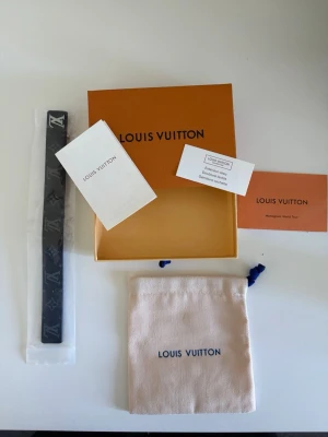 LVarmband  - Snyggt svart armband med klassiskt monogrammönster och silverfärgat LV-spänne. Bältet kommer med originalförpackning, dustbag och certifikat. Perfekt accessoar för att lyfta din outfit.