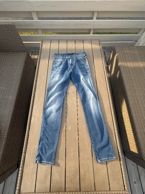 Ljusblå replay jeans  - Säljer ett par ljusblå jeans med raka ben och klassisk femficksmodell. Jeansen har en snygg tvätt med slitningar och är tillverkade i denim. Passar perfekt till en avslappnad stil. Längd 32 