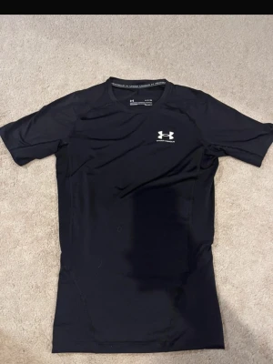 Under Armour T shirt  - Under Armour Compression Shirt i svart.  Väldigt fint skick och sparsamt använd. Sitter tajt och är perfekt för gym, fotboll, löpning eller annan träning. Säljs eftersom den inte kommer till användning. Skickas snabbt. Pris kan diskuteras vid snabb affär! 💯