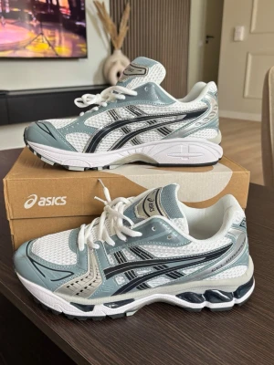 ❄️Asics gel keyano 14 ice blue❄️ - Snygga Asics sneakers i vitt, ljusgrått och silver med svarta detaljer. Skorna har en sportig design med meshpaneler för bra ventilation och syntetiska förstärkningar. Klassisk snörning och bekväm, stötdämpande sula. Perfekta för en trendig streetwear-look. Aldrig använda. Storlek 42. Skriv bara om du är seriös! Kom privat för flera frågor.