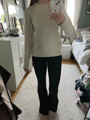 Beige stickad tröja från Vero Moda - Säljer en enkel och stilren beige stickad tröja från Vero Moda. Tröjan har rund halsringning, långa ärmar och ribbade muddar vid ärmslut och nederkant. Perfekt att matcha med jeans eller kjol för en clean look.