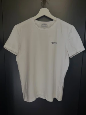 Vit t-shirt från Dondup (XS) - Klassisk vit t-shirt från Dondup med liten logga på bröstet. T-shirten har rund halsringning och korta ärmar. Tillverkad i mjuk bomull för en skön känsla och enkel stil som passar till det mesta.