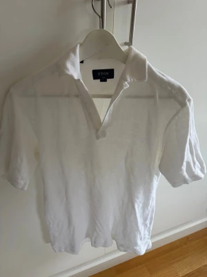 Vit polo i frotté från Eton - Klassisk vit polo i frotté från Eton med korta ärmar och öppen krage. Tillverkad i mjuk bomull som känns skön mot huden. Enkel och stilren design som passar till det mesta. Perfekt för dig som gillar en clean och tidlös look.