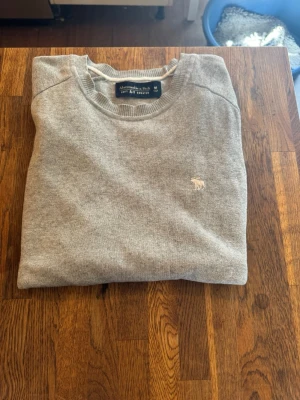 Abercombie & fitch Tröja - Säljer mina gråa abercombie & fitch tröja då den inte passar mig. Den är använd några gånger, det finns ett litet hål vid armhålan, går enkelt att laga. Bortsett från det så är den i fint skick. Om ni undrar något eller vill ha fler bilder så är det bara att skriva till mig här på plick. Pris kan diskuteras. Nypris är ca 400kr