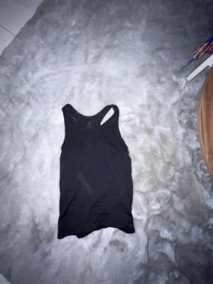 Svart sportlinne från H&M - Säljer ett svart sportlinne från H&M Sport. Linnet har brottarrygg och är gjort i ett stretchigt material som passar perfekt till träning eller gym. Enkel och stilren design som är lätt att matcha med andra träningskläder.