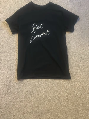 Svart Saint Laurent t-shirt - Svart t-shirt från Saint Laurent med vit  logga på bröstet. Small