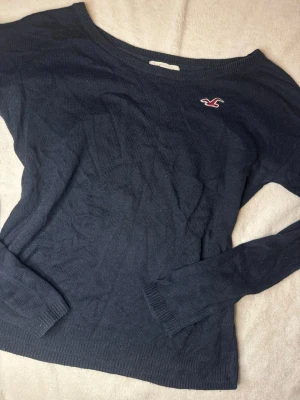 Mörkblå/svart tröja från Hollister - Säljer en skit snygg mörkblå/svart tröja från Hollister. Tröjans passform är lös i midjan och passar perfekt nu inför hösten! Mått kan skickas privat och pris kan diskuteras!