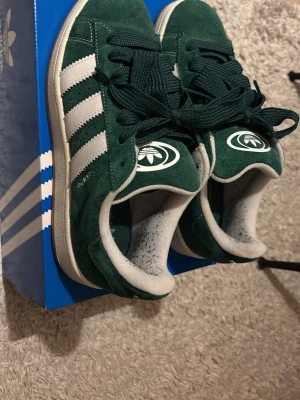 Gröna Adidas campus  - Säljer ett par gröna Adidas campus. Endast använda en gång ute dom är tyvärr för små för mig. Det är stl 40. Kan tänka mig att gå ner i pris kom med rymliga prisförslag.