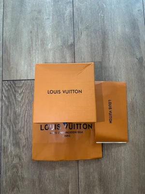 Louis Vuitton Bälte – Helt nytt med box & tillbehör - Säljer ett snyggt Louis Vuitton-bälte i vitt med svart LV-spänne, komplett med tillhörande box och påse som syns på bilderna. Bältet är helt nytt, oanvänt och i utmärkt skick. Perfekt som en lyxig accessoar för att lyfta vilken outfit som helst eller som en fin present. 