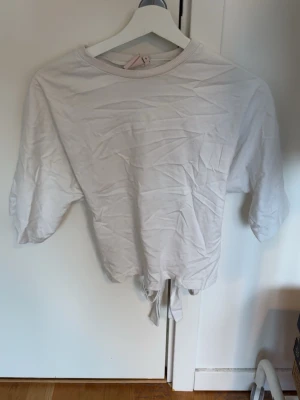 Nelly open back tie tee - T-shirt från Nelly som man knyter i ryggen, säljer för den inte kommer till användning och har då använts 1-2 gånger 