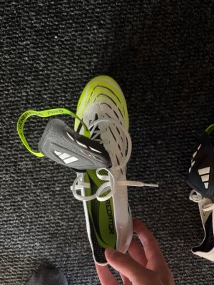 Adidas Predator fotbollsskor vit/svart/gul - Säljer mina predators som jag använt fåtal gånger, finns inga deflekter och skicket är bra.