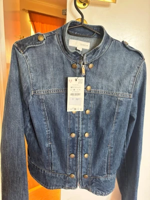 Mörkblå jeansjacka med guldknappar - Trendig jeansjacka från zara, köpt denna månad. Jag vill sälja den eftersom jag har köpt en annan som passar mig bättre, som ni ser lappen är fortfarande kvar fast den har ramlat ner. Har inte tagit på mig