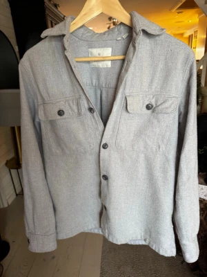 Ljusgrå overshirt med bröstfickor  - Det står att den är storlek XS i tröjan men den passar för S.      PRIS kan diskuteras