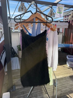 Svart fransig bandeau kortklänning🖤 - Säljer en svart kort klänning från Gina Tricot utan axelband (tubklänning) och fransiga detaljer över hela klänningen🖤