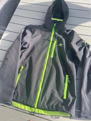 Svart jacka med neon-detaljer - Säljer denna stilrena jacka som är vattenavisande och ger dig en sportig look. Storlek S. Denna är i nyskick och inte använd. Nu säljes den för 299 men priset kan diskuteras! Hör av dig vid frågor eller funderingar!!