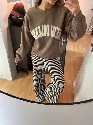 Brun sweatshirt - Säljer en oversized brun sweatshirt med vit text 'NEW ORLEANS' på bröstet. Den är ifrån hm och i storlek S