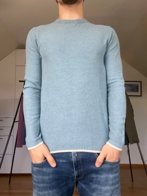Ljusblå stickad tröja herr - Ljusblå stickad tröja från Riley tillverkad i 100% bomull. Strl S. Inga defekter. Modellen är 178 cm och väger 77kg. Hör gärna av dig vid frågor!