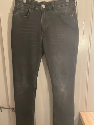 Svarta skinny jeans med slitningar - Snygga svarta skinny jeans med diskreta slitningar och tvättade detaljer. Jeansen har klassisk femficksdesign och smal passform hela vägen ner. Perfekta för en trendig och avslappnad look.