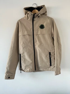 Vindjacka - Vindjacka från Moncler. Strl 3 (M/L), liten i storleken så skulle säga att det mer är S/M. En liten prick finns på bröstet, se bild. 