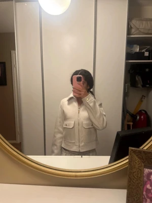 Beige jacka från Zara med fickor - Säljer en beige jacka från Zara med två stora fickor framtill och dragkedja. Är i ett mjukt material som känns skönt. I storlek XS. I beige/vit, tror orginal pris var 400 kr. Har använt inte så många gånger