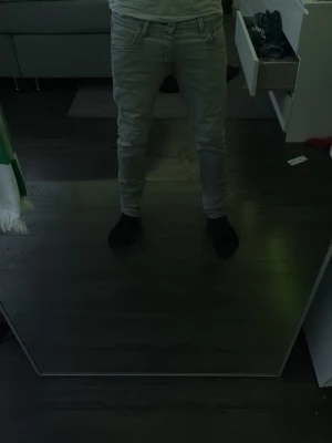 Ljusgrå slim fit jeans - Säljer ett par ljusgrå slim fit jeans från Jack and Jones med klassisk femficksdesign och snygga sömmar på bakfickorna. Jeansen har normal midja och raka ben, perfekta till en avslappnad stil. Materialet är mjukt och stretchigt för extra komfort.