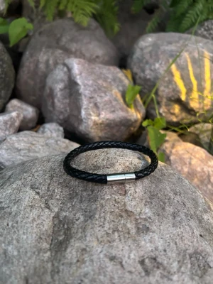 Svart flätat läderarmband - Snyggt svart armband i flätat läder med ett stilrent magnetlås i silverfärgad metall. Perfekt accessoar för dig som gillar en enkel men trendig look. Passar både till jeans och t-shirt eller mer uppklätt. Lätt att ta på och av tack vare det smidiga låset.