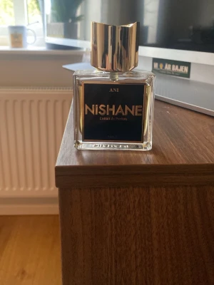 Nishane Ani Extrait de Parfum - Lyxig parfym från Nishane, Ani Extrait de Parfum. Flaskan är fyrkantig i genomskinligt glas med svart och gulddetaljer samt en elegant, guldig kork. Doften är känd för sin unika och intensiva karaktär. Perfekt för dig som vill sticka ut med en exklusiv signaturdoft. Nypris 2250kr skriv för fler frågor 
