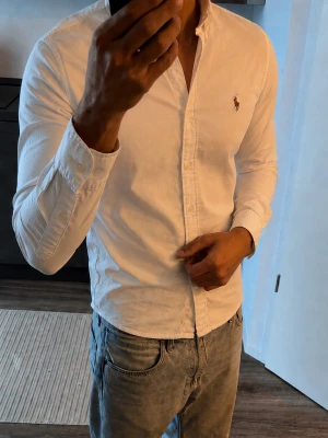 Vit Ralph Lauren Skjorta - Klassisk vit skjorta från Ralph Lauren med button-down krage och broderad logga på bröstet. 