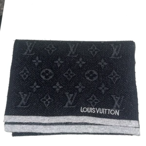 Louis Vuitton svart ullhalsduk - Snygg svart halsduk från Louis Vuitton med klassiskt monogrammönster och grå. Vet ej om de äkta men känns och ser ut som äkta 