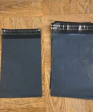 Svarta/ gråa frakt påsar 10 st - Ett gäng svarta plastpåsar med självhäftande förslutning. Perfekta för att skicka paket eller förvara saker. Påsarna är rektangulära och har en matt finish. Säljes i bunt. Dessa på bilden är 16,5 cm bred och 23 cm lång. Har även andra storlekar. Om ni undrar är de bara att ställa frågor 