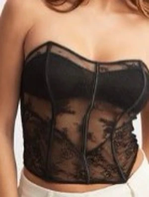 Svart spetskorsett med meshdetaljer - Trendig svart korsett med transparent mesh och spetsdetaljer. Axelbandslös design med markerade sömmar och lätt formande effekt. Perfekt för att skapa en edgy och snygg look.(Oanvänd, prislapp kvar!)