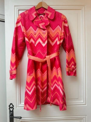 Vintage Missoni kappa - Säljer en vintage missoni trench coat. Kappan har dubbelknäppning, bred krage, bälte i midjan och dekorativa knappar vid ärmar och axlar. 