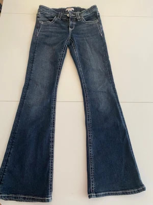 Blå bootcut jeans med broderade fickor - Snygga blå bootcut jeans med jätte snygga vita mönster på,storlek 152 och är från Gina tricot Young💕