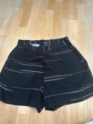 Svarta shorts med vita ränder från Lindex - Aldrig använda dock tvättade en gång i handtvättsprogrammet , färgen på tyget är grådassigt och lite luddigt vet inte varför. Väljer därför mycket bra på beskrivning, se dock bilderna innan köp sker.