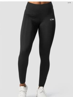 Svarta leggings från ICANIWILL - Säljer ett par svarta leggings från ICANIWILL med logga på höften och längs benet. 