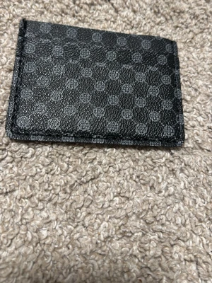 Svart kortfodral med mönster - Snyggt svart kortfodral i läderimitation med diskret mönster av små cirklar. Perfekt för att hålla koll på dina kort och enkelt att ha i fickan. Stilren och minimalistisk design som passar till det mesta.