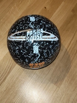 Svart Panna fotboll - Cool svart boll från Panna House med vitt stjärnmönster och texten 'May the Hood Be With You'. Perfekt för streetfotboll eller tricks. Rund form och greppvänlig yta gör den enkel att hantera på olika underlag. Köpt för 600kr för 2 månader sen 