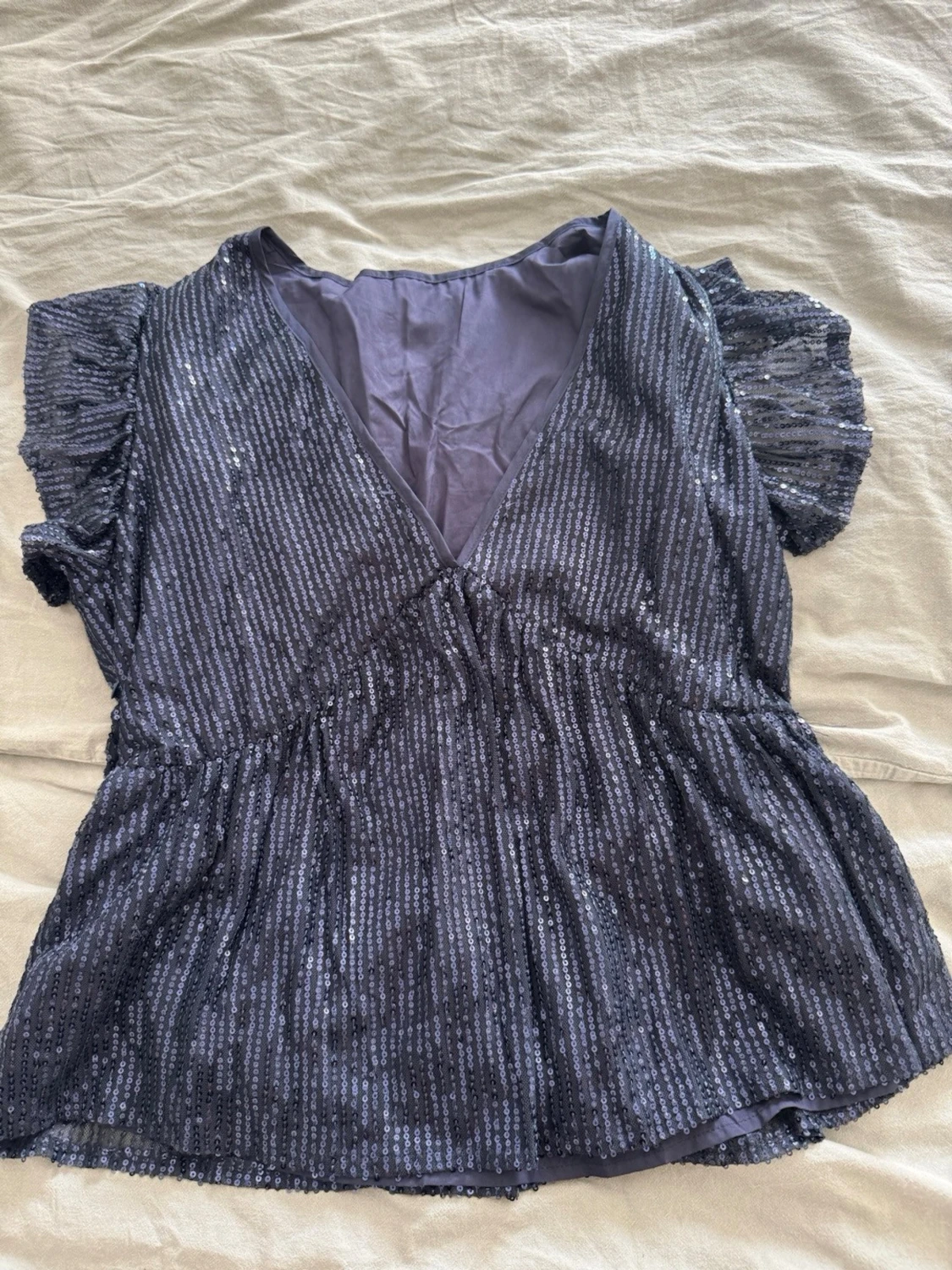 Glittrig svart blus med volangärm