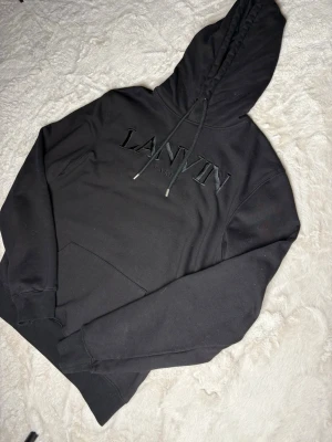Svart lanvin hoodie - Säljer en sprillans ny lanvin hoodie i storlek M/L, den har aldrig används och har inga fläckar eller hål. Kom gärna privat för mer information eller bilder på hoodien. Priset kan alltid ändras😊