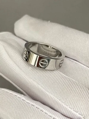 Silverfärgad ring med skruvdetaljer - Stilren ring i silverfärgad metall med blanka ytor och ingraverade skruvliknande detaljer runt om hela ringen. Perfekt för dig som gillar minimalistisk och modern design.