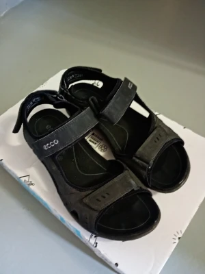Ecco Offroad Sandaler stl. 43 - Säljer ett par Ecco sandaler till herr i mycket gott skick enligt bilder. Använda fåtal gånger endast. Otroligt sköna då de är ergonomiskt utformade för fotsulan. Kan behöva rengöras. Se specifikationer längst ned.   Nypris: 1400 SEK Begagnat pris: 500 SEK Mitt pris: 398 SEK  Skriv vid frågor och se gärna mina andra annonser! Skapar gärna deals och paketpriser för just dina behov!   Skickas snabbt och spårbart med alla möjliga fraktsätt.  Produktinformation Material & care Upper material: Synthe
