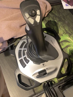 Logitech joystick och ratt till PC - Säljer ett paket med Logitech joystick och ratt för PC. Joysticken har flera knappar och ergonomiskt handtag, perfekt för flygsimulatorer. Ratten har gummiklädd yta, flera knappar och D-pad, samt medföljande pedalset. Båda ansluts med USB.