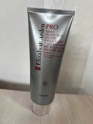 Elizabeth Arden PRO SPF 30 Lotion - Elizabeth Arden PRO Triple Protection Factor Face & Body är en silvrig lotion med SPF 30. Tuben rymmer 120 ml och skyddar mot UVA-strålar. Innehåller DNA Enzyme Complex och antioxidanter för extra skydd och vård.