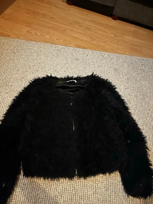Svart fuskpälsjacka Gina Tricot - Säljer en svart fuskpälsjacka från Gina Tricot med dragkedja framtill. Jackan har lång ärm, rund halsringning och är helfodrad med glansigt tyg. Perfekt för dig som vill ha en trendig och mysig look under vintern. Kom gärna med bud säger ja till allt nästintill🩷