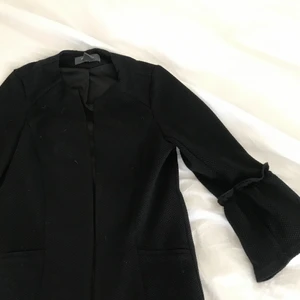 Svart kappa - En svart kortare kappa med utsvängda armar