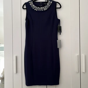 Dam Pärl klänning  - Fin klänning i storlek 4 från Usa vilket är 36 men är rätt stretchy så passar slim 38. Nacken har pärl detaljer och dragkedja i ryggen. Lite slits bakom men kan lätt stängas. Väldigt elegant och färgen ör marinblå. Landar precis övanpå knäna och jag är 175cm lång.