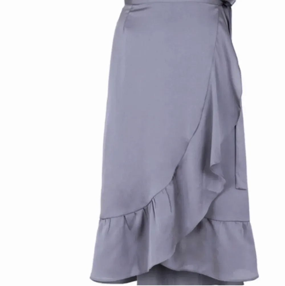 Säljer denna omlott satin Neo Noir kjol i mörkgrått/silvrigt. Super fin till vår/sommar🆒🆒🆒. Kjolar.