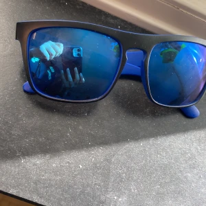 Vanliga solglasögon  - Den passar till sommaren. Den är mörk blå. Säljer den för att har inte använt den det är på bra skick. Säljer den för lågt pris.